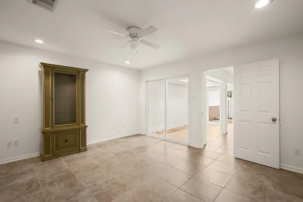 an empty room with closet and a ceiling fan