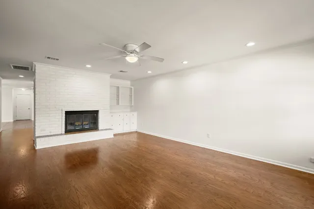 an empty room with a fireplace and fan