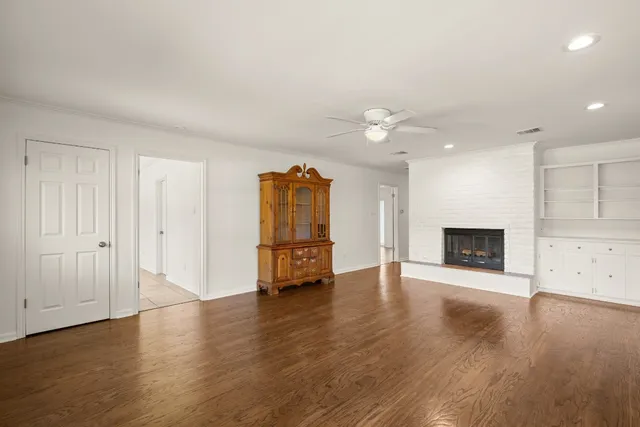 an empty room with a fireplace and wooden floor
