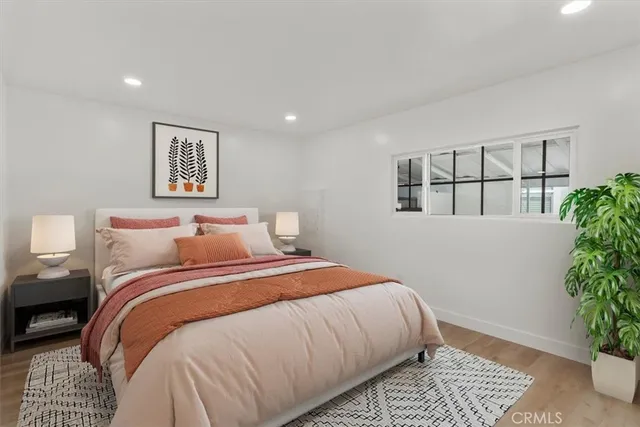 a bedroom with a bed and a potted plant