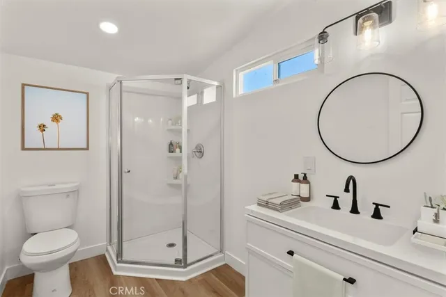 a bathroom with a sink a mirror a toilet and a shower