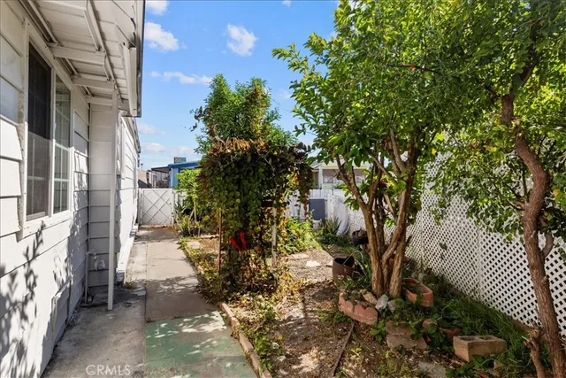 a view of a swimming pool with lawn chairs and plants
