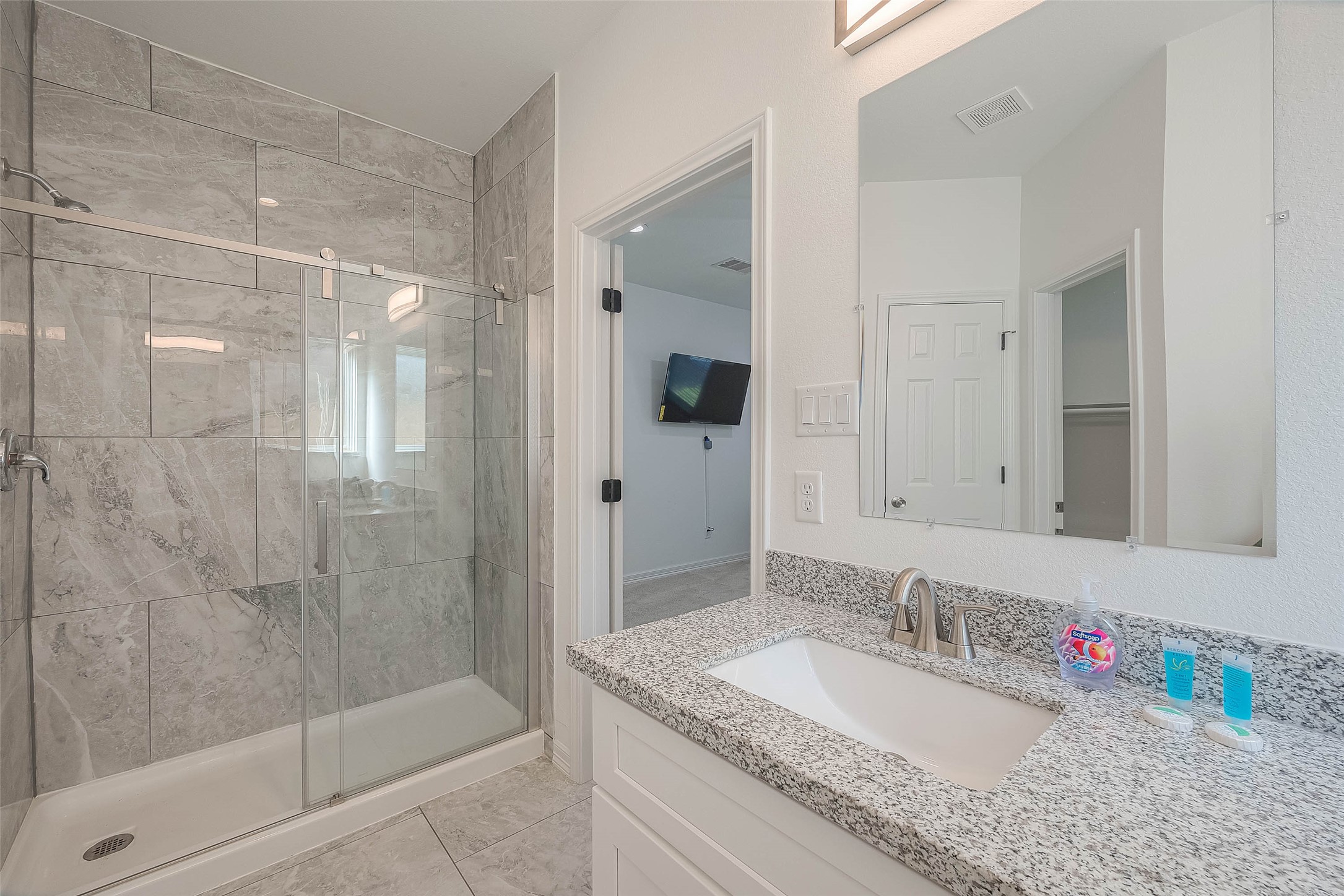 4633 Larkspur Street Houston, TX 77051 - Photo 12 of 48 a bathroom with a granite countertop sink a mirror and shower