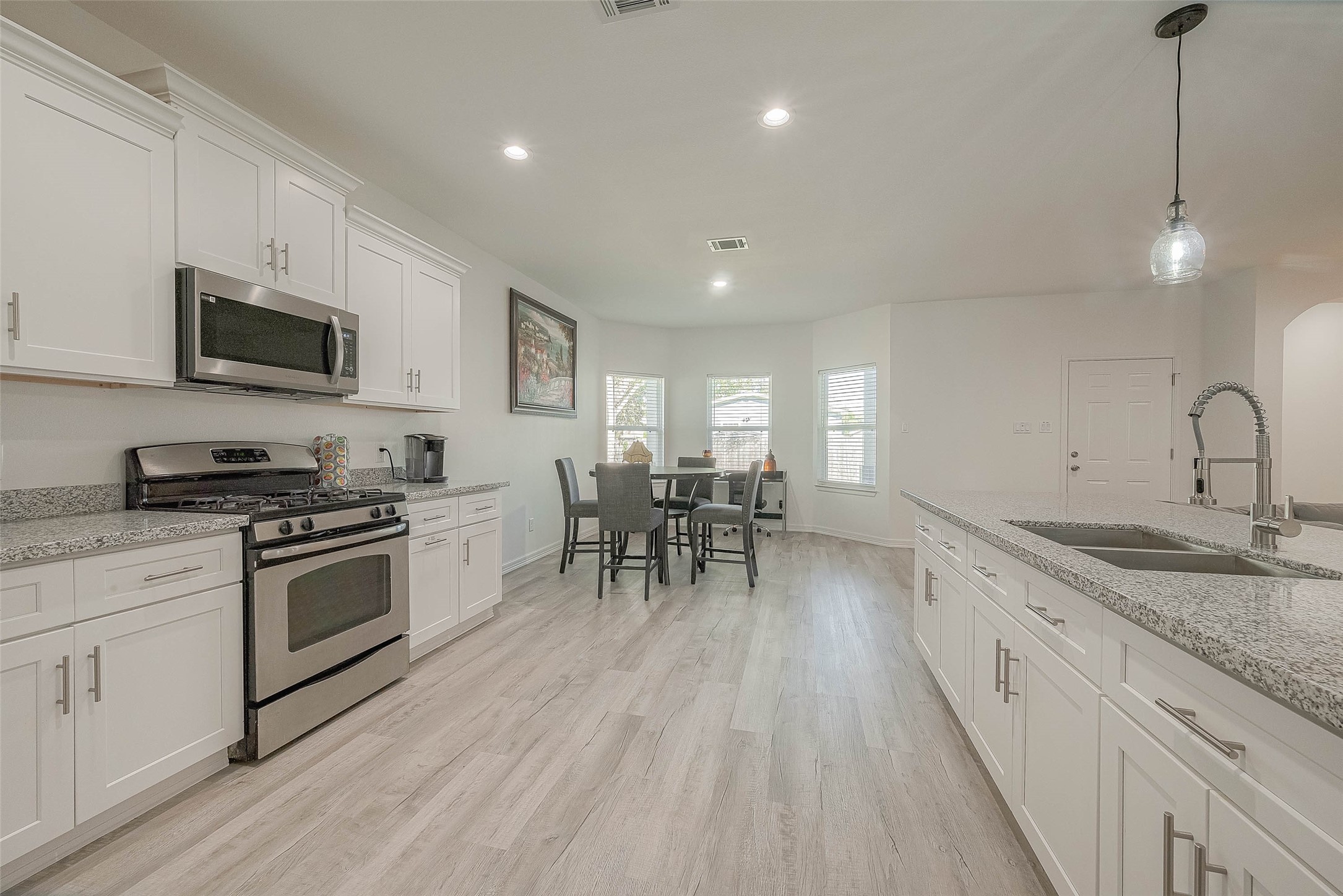 4633 Larkspur Street Houston, TX 77051 - Photo 38 of 48 a kitchen with stainless steel appliances granite countertop a stove top oven a sink a dining table and chairs with wooden floor