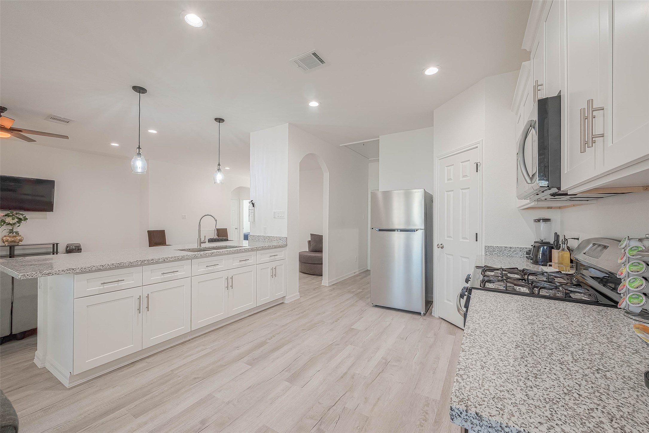 4633 Larkspur Street Houston, TX 77051 - Photo 43 of 48 a large kitchen with stainless steel appliances granite countertop a stove a sink a refrigerator and white cabinets with wooden floor