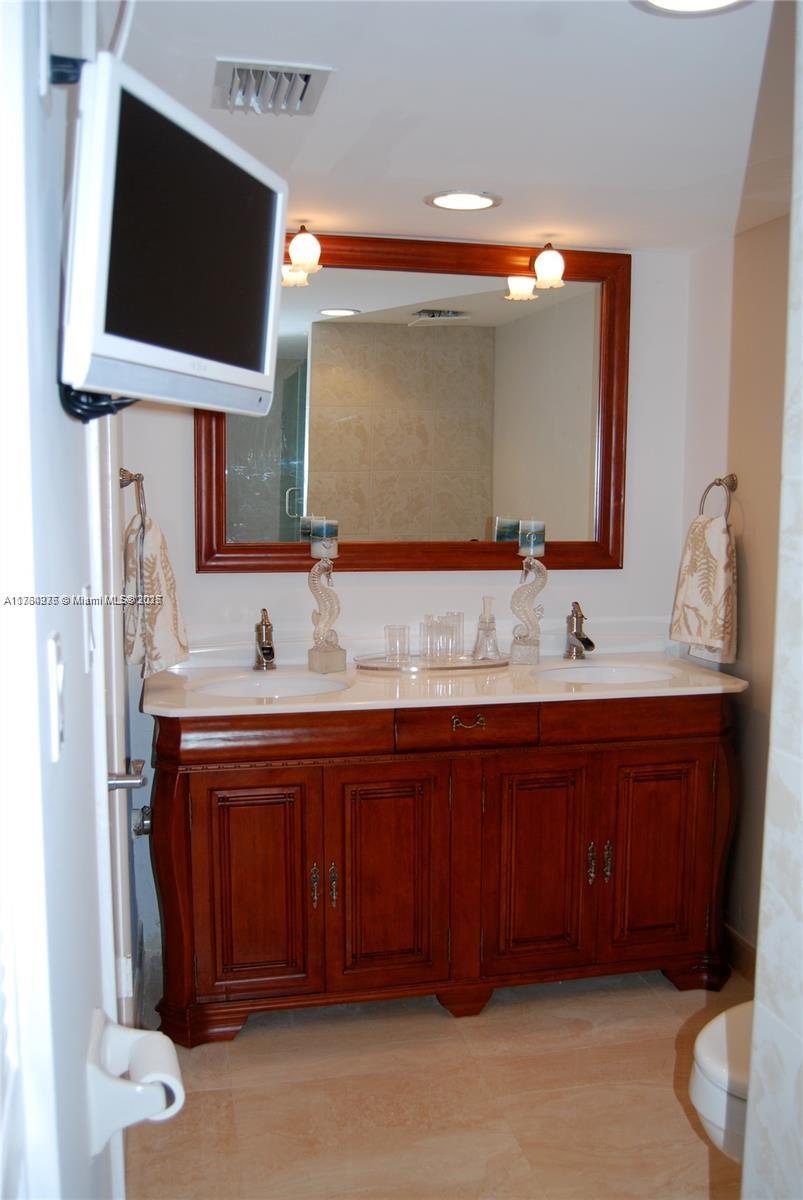 6423 Collins Avenue, Unit 901 Miami Beach, FL 33141 - Photo 13 of 17 a bathroom with a sink double vanity and a mirror