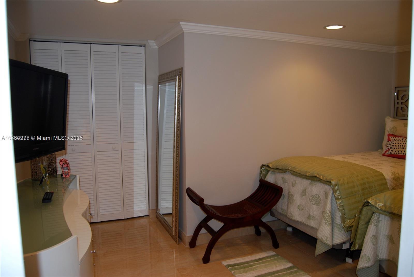 6423 Collins Avenue, Unit 901 Miami Beach, FL 33141 - Photo 15 of 17 a bedroom with a bed and a chair