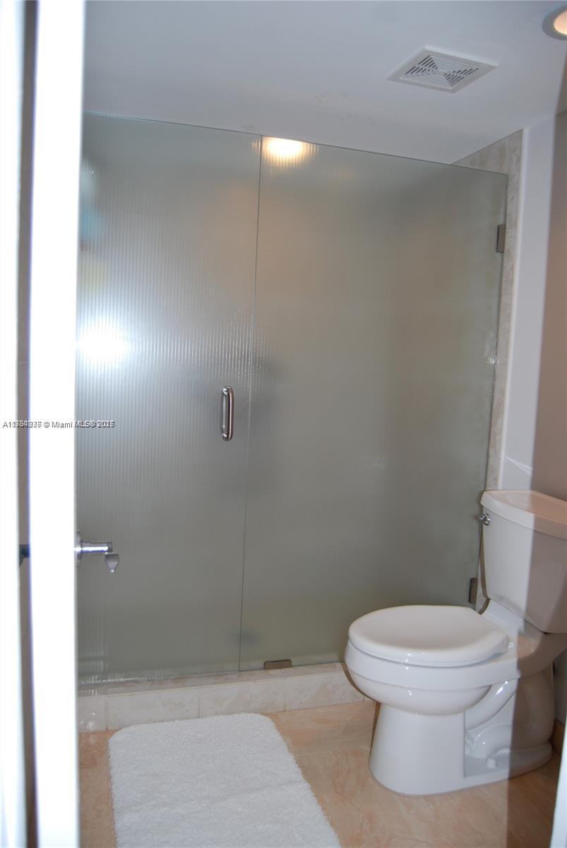 6423 Collins Avenue, Unit 901 Miami Beach, FL 33141 - Photo 16 of 17 a white toilet sitting next to a bathroom sink