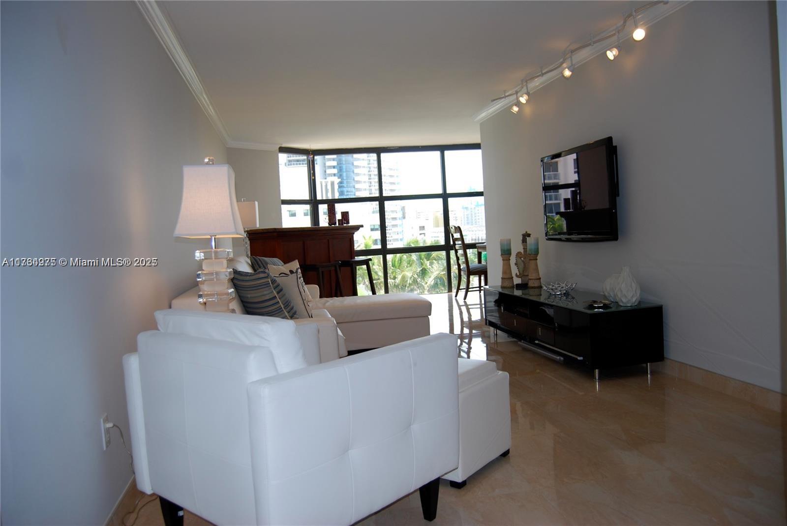6423 Collins Avenue, Unit 901 Miami Beach, FL 33141 - Photo 9 of 17 a living room with furniture and a flat screen tv