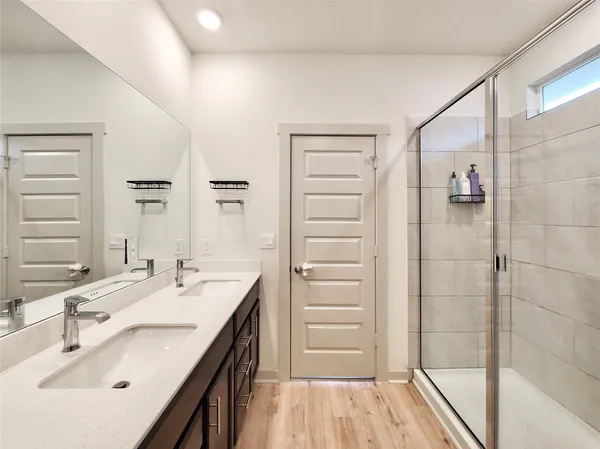 a bathroom with a double vanity sink a mirror and a shower