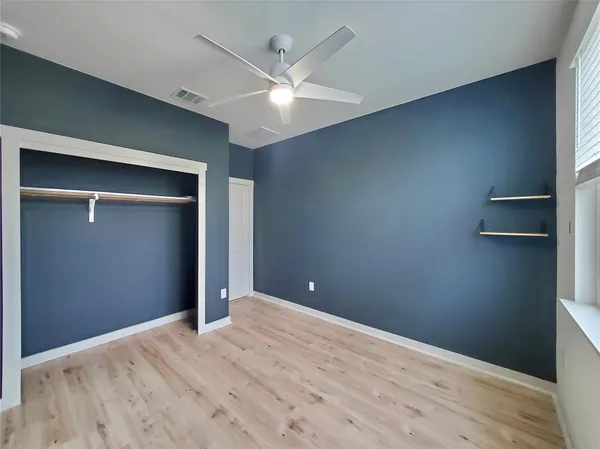 a view of empty room with wooden floor