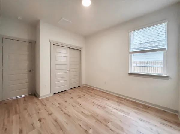 an empty room with windows and closet