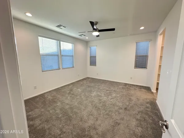 en empty room with windows and ceiling fan