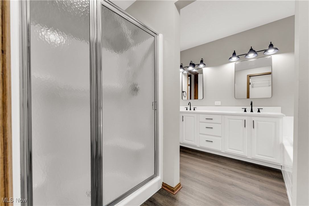 5327 Jaycox Road North Ridgeville, OH 44039 - Photo 20 of 36 Bathroom featuring a shower stall, wood finished floors, and double vanity