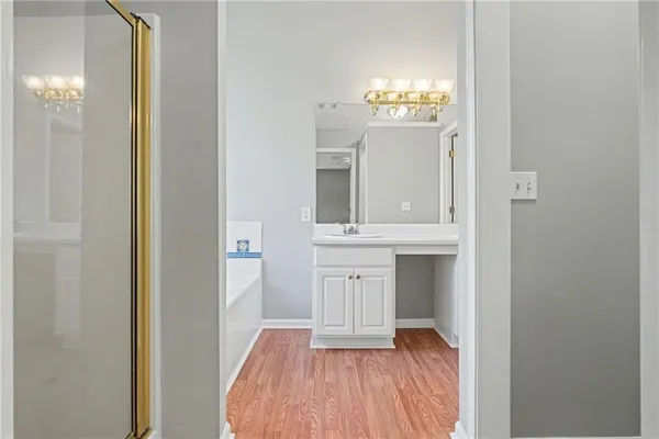 a view of a hallway with wooden floor and a chandelier