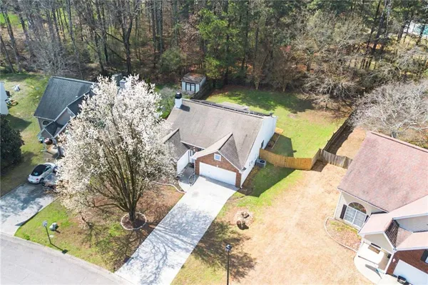 an aerial view of a house with swimming pool and large trees