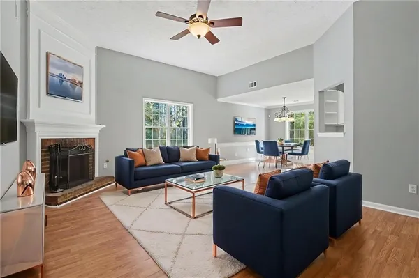 a living room with furniture a fireplace and a flat screen tv