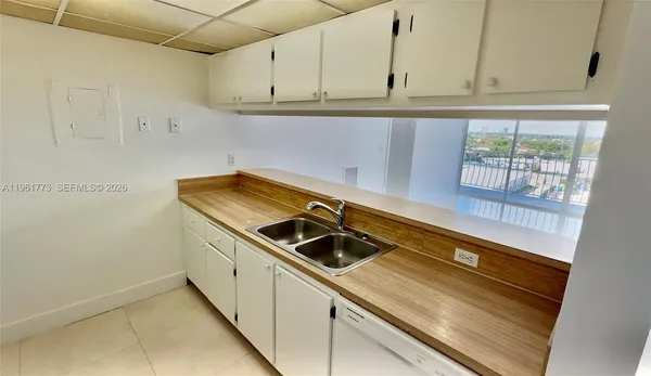 a kitchen with stainless steel appliances white cabinets and a refrigerator
