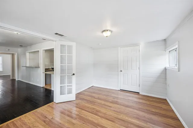 a view of empty room with wooden floor