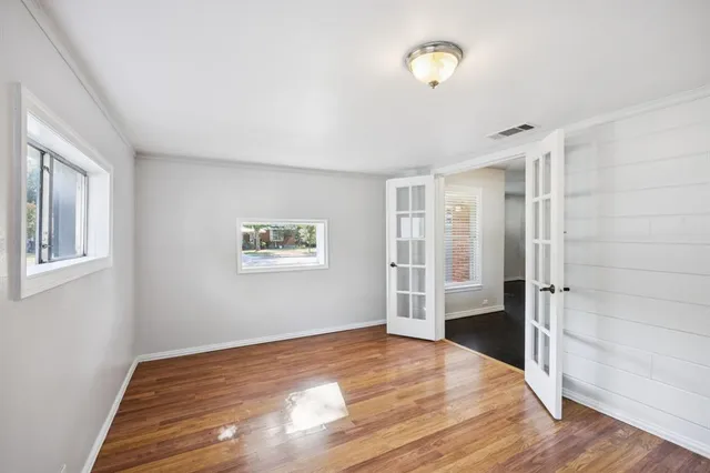a view of empty room with wooden floor