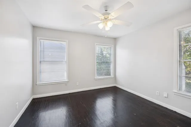 an empty room with wooden floor and window