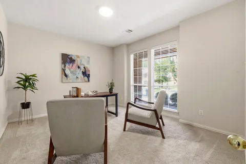 a view of a workspace with furniture and a window