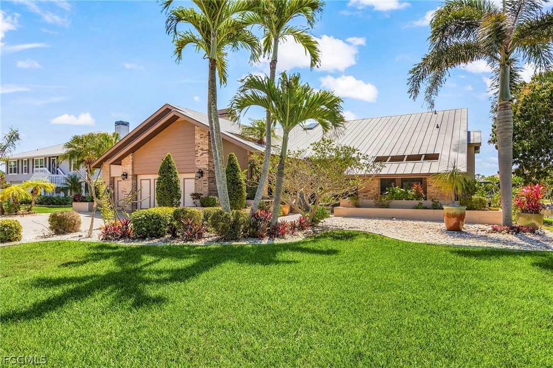 7747 Grande Pine Road Bokeelia, FL 33922 - Photo 1 of 45 a front view of a house with swimming pool having outdoor seating