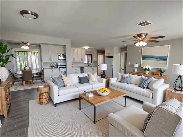 a living room with furniture kitchen view and a chandelier