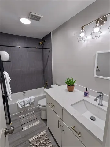 a bathroom with a sink mirror vanity and toilet