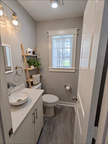 a bathroom with a sink toilet and window