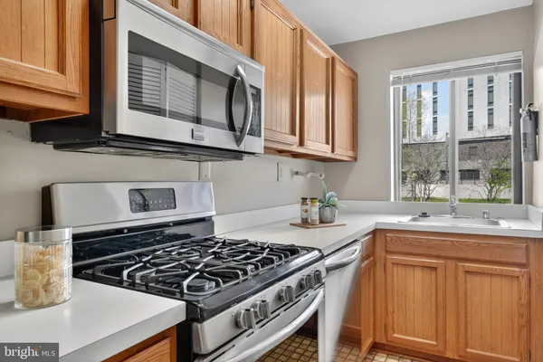 a kitchen with granite countertop a stove sink and cabinets