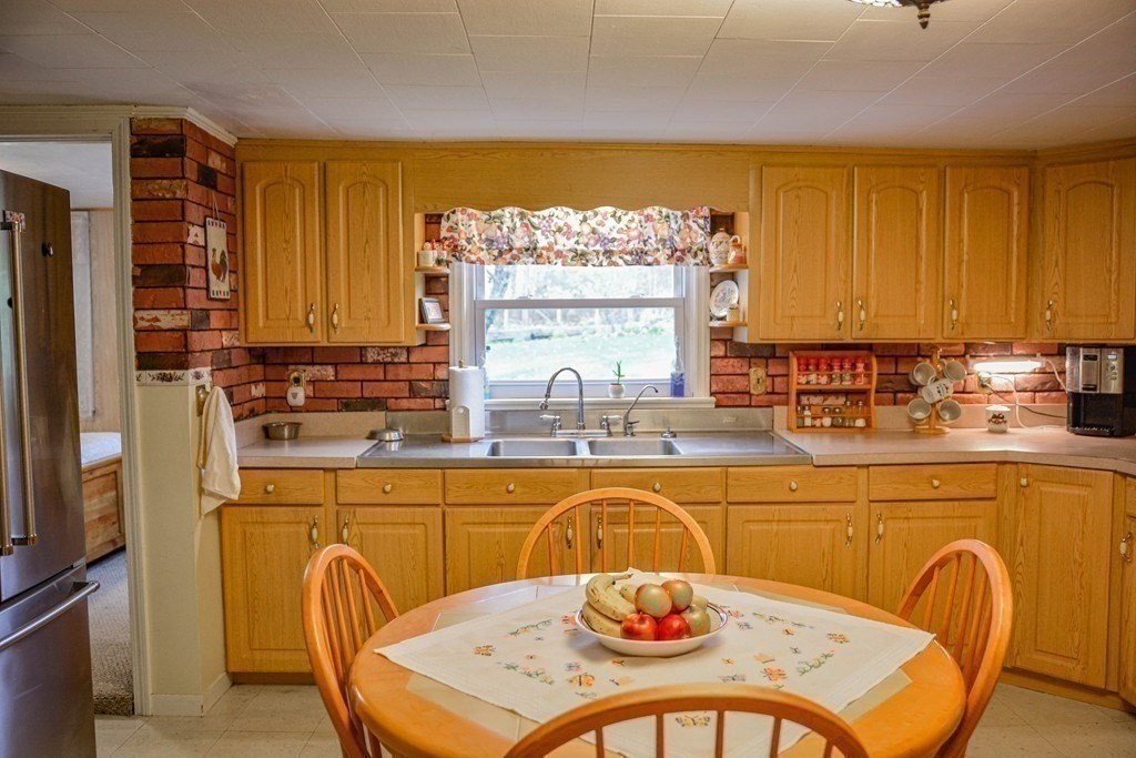 345 Richardson Road Ashby, MA 01431 - Photo 15 of 37 a kitchen with a table chairs in it and wooden cabinets