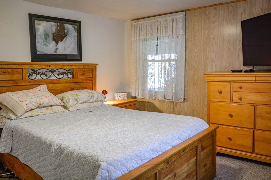 345 Richardson Road Ashby, MA 01431 - Photo 21 of 37 a bedroom with a bed and a flat screen tv