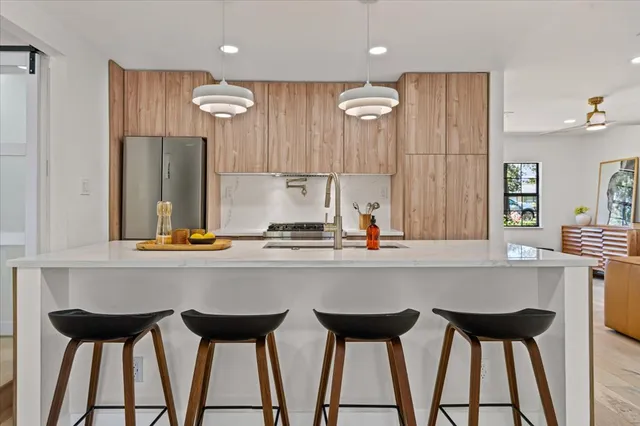 a kitchen with a table chairs refrigerator and wooden cabinets