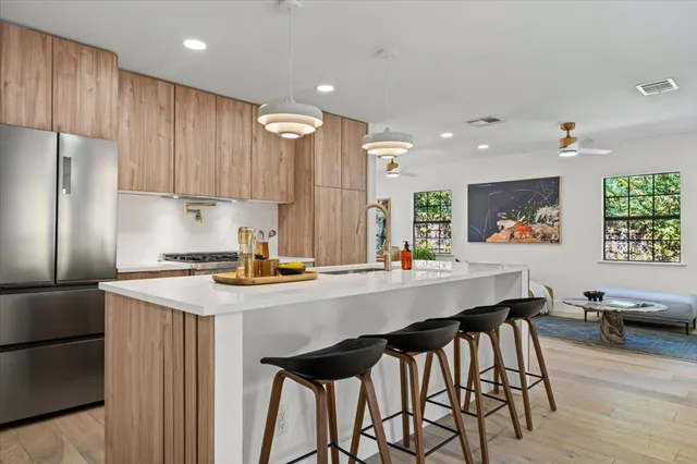 a kitchen with stainless steel appliances a table and chairs in it