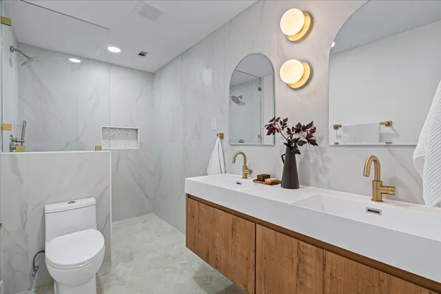 a bathroom with a sink vanity mirror and toilet