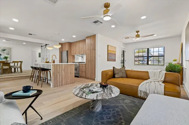 a living room with furniture and a dining table with kitchen view