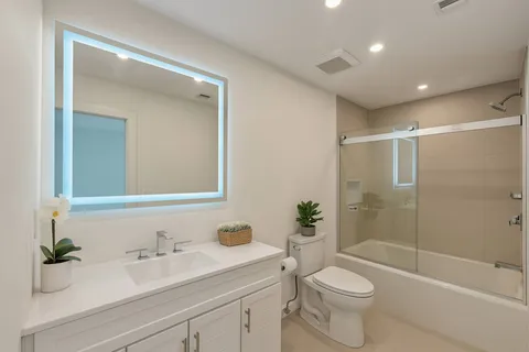 a bathroom with a sink a toilet and shower