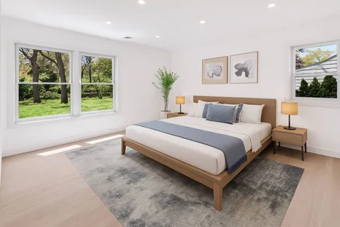 a bedroom with a bed and a large window