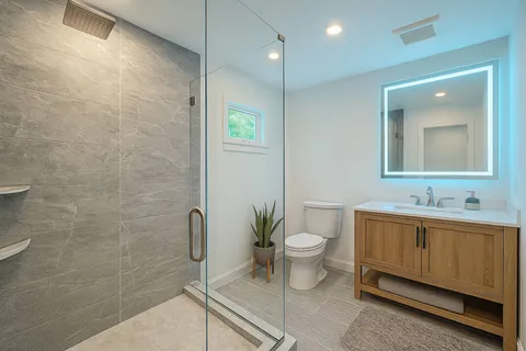 a bathroom with a toilet a sink and mirror