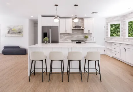 a kitchen with stainless steel appliances granite countertop a kitchen island a stove a dining table and chairs with wooden floor