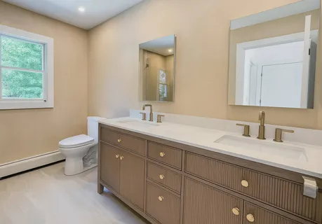 a bathroom with a double vanity sink a toilet and a mirror