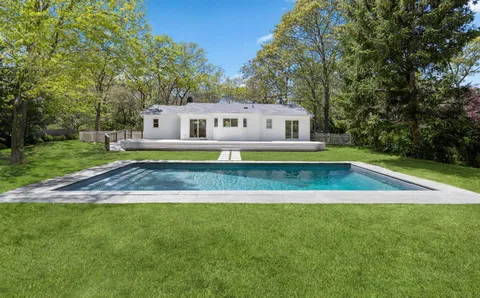 a view of a house with a swimming pool and a yard