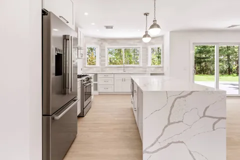 a kitchen with stainless steel appliances granite countertop a refrigerator and a sink