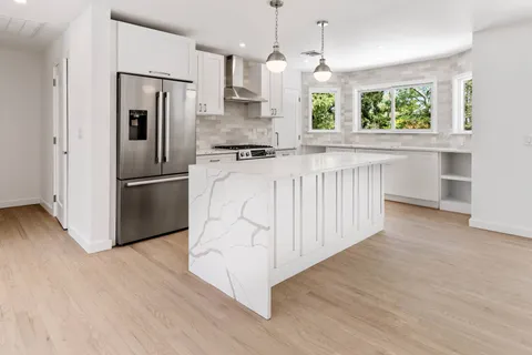 a kitchen with stainless steel appliances a refrigerator sink and white cabinets