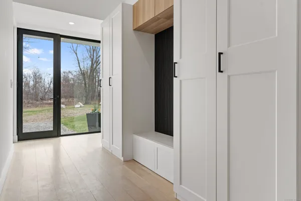 a view of a white house with a big yard and large trees