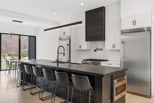 a kitchen with stainless steel appliances granite countertop a stove a sink and a refrigerator