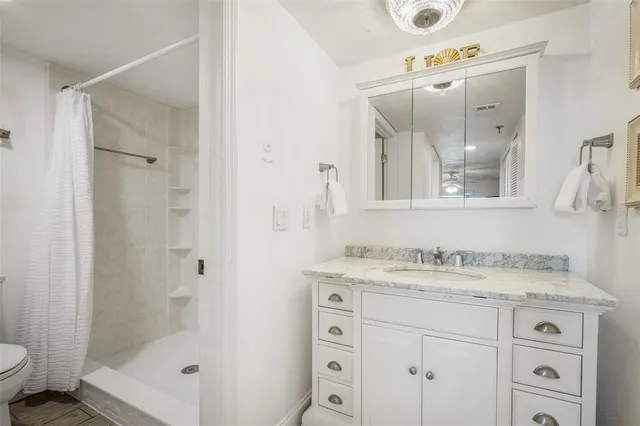 a bathroom with a granite countertop sink a mirror and a shower