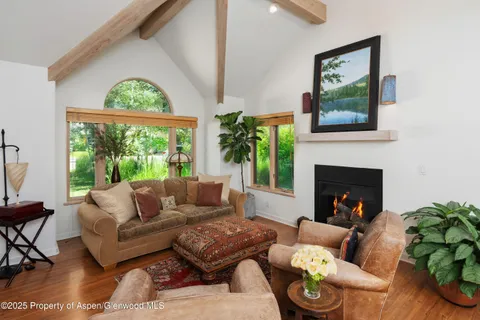 a living room with furniture fireplace and a large window