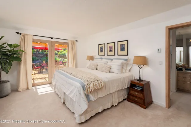 a bedroom with a bed and a potted plant
